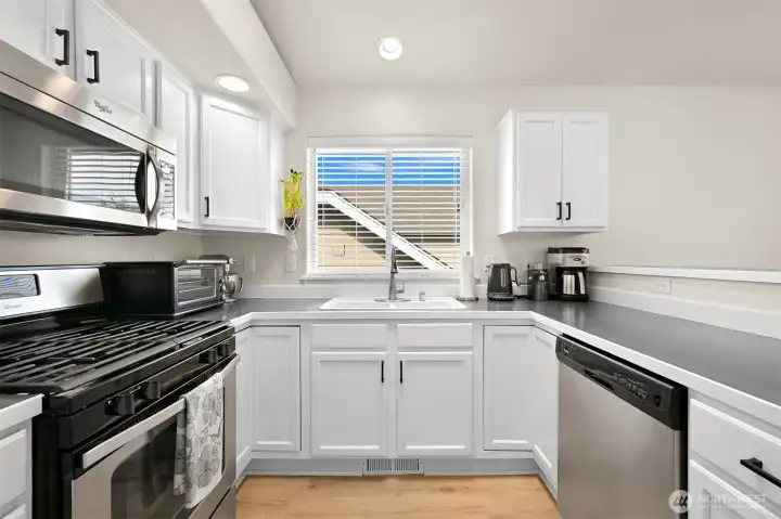 White-painted solid oak cabinets and stainless steel appliances White-painted solid oak cabinets and stainless steel appliances