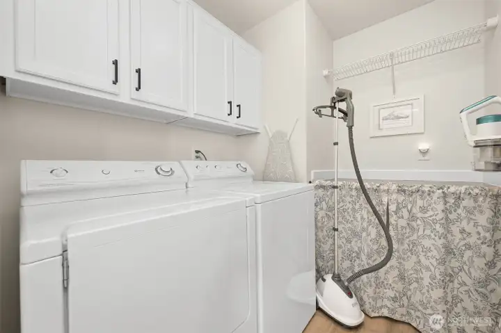 Laundry room with built-in cabinets and folding shelf. Washer & dryer are included in sale. Laundry room with built-in cabinets and folding shelf. Washer & dryer are included in sale.