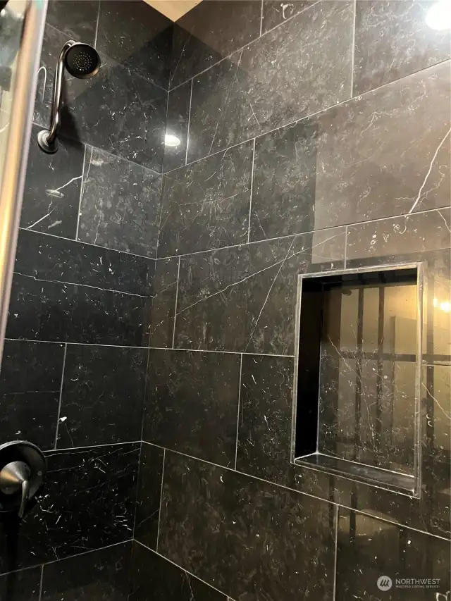 Elegant oversized shower, beautiful black tiles, with cubby and a seat
