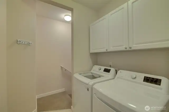 In-unit washer and dryer with built-in cabinetry for extra storage.