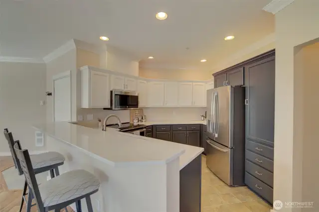 The beautifully designed kitchen offers quartz countertops and stainless appliances.