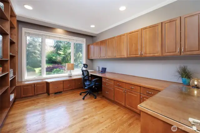 Home office with abundant built-in shelves & cabinets.