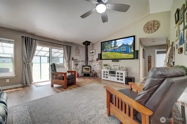 Living room is spacious and cozy with it's wood stove (see wood in outside storage).