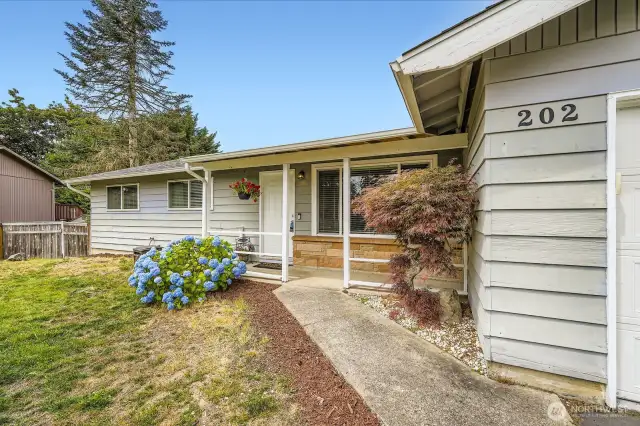 Walkway leads to a covered front porch that protects you from the elements.