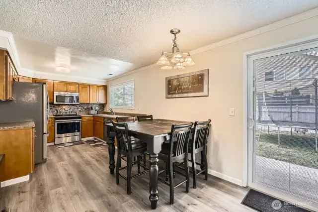 The spacious kitchen features abundant cabinet and counter space. A slider leads to the patio and backyard.