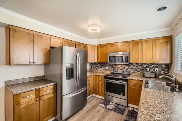 Beautiful countertops and full height backsplash complement this kitchen.