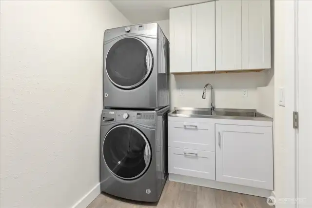 Newly remodeled laundry room with added cabinets and utility sink