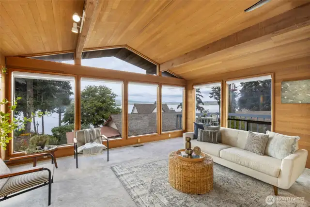 Mid-century modern with vault inlaid wood ceilings give a warm glow to this room with floor to ceiling windows!