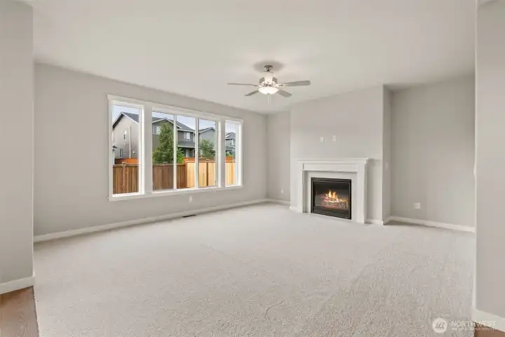 Family room is pre-wired for easy installation of TV and entertainment equipment and features a cozy gas fireplace with tile surround for those cooler evenings. Standard ceiling fan provides light and comfort. Oversized windows allowing lots of natural light into the open family room featuring 9' ceiling.