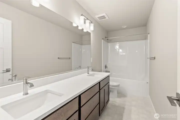 Main Full bath with double vanity undermount sinks with contemporary fixtures, quartz countertop and tub/shower.