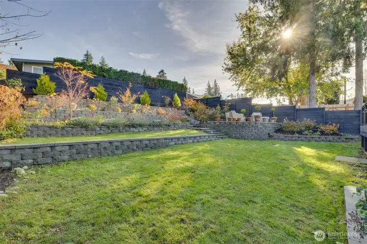 View of the terraced backyard and elevated patio with lake views
