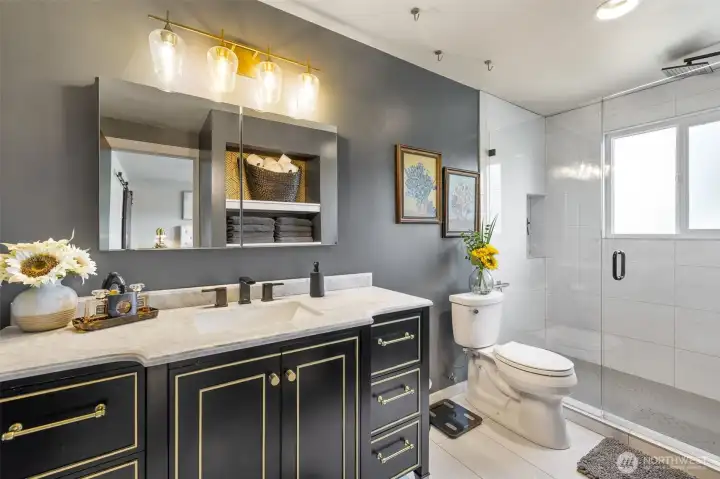 Primary bath remodel with newer vanity, lighting, flooring and shower with full height tile