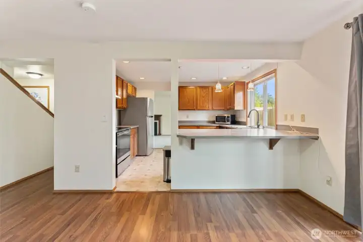 Open kitchen layout with stainless appliances, a breakfast bar, and clear sightlines into the dining area — great for hosting and casual meals.