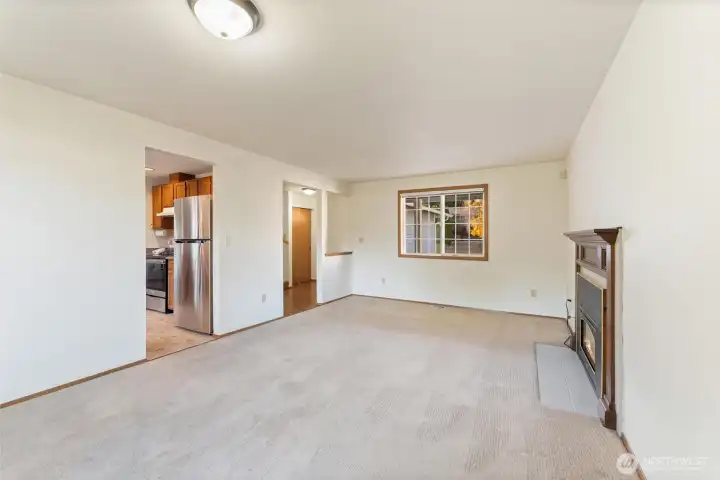 Spacious living room centered around a classic gas fireplace and large picture window. A warm and inviting space perfect for relaxing or entertaining.