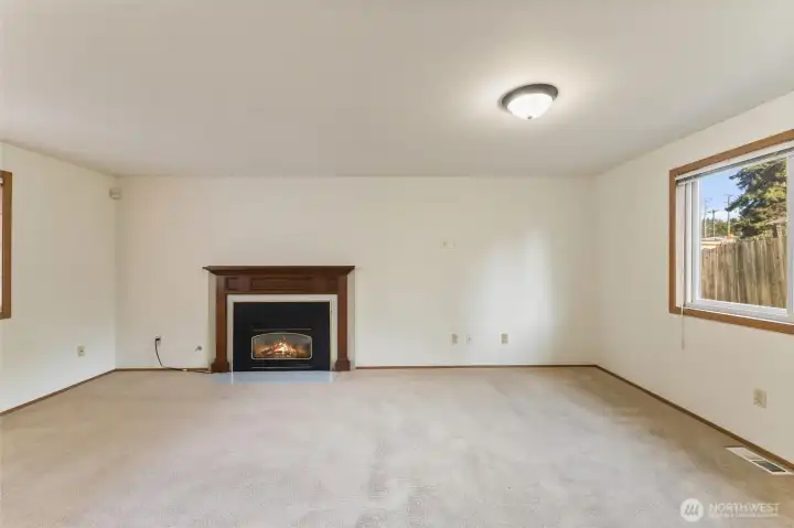 Comfortable living area highlighted by a classic gas fireplace with a wood mantel, perfect for relaxing evenings and creating an inviting focal point for the space.