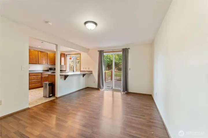 Open dining space with laminate flooring and direct access to the back deck through sliding glass doors — ideal for indoor/outdoor entertaining and gatherings.