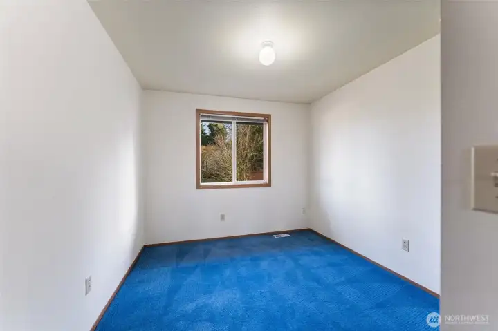 Comfortable secondary bedroom with a large window overlooking the backyard, providing great natural light and a quiet retreat.
