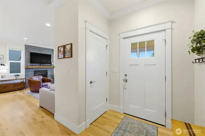 Bright craftsman entry with hardwood floors, custom millwork, and clear sightlines into the open-concept living room with gas fireplace. Bright craftsman entry with hardwood floors, custom millwork, and clear sightlines into the open-concept living room with gas fireplace.