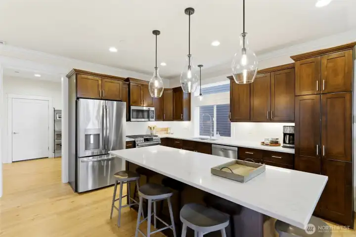 Chef's kitchen featuring oversized quartz island, alder shaker cabinets, and walk-in pantry — the heart of the home. Chef's kitchen featuring oversized quartz island, alder shaker cabinets, and walk-in pantry — the heart of the home.
