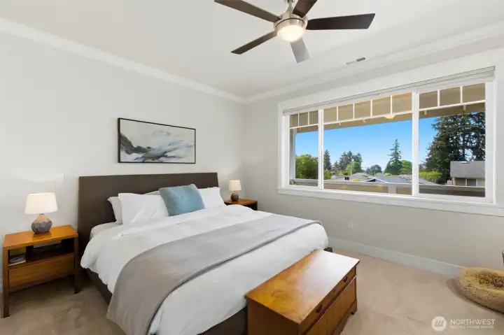 Spacious primary suite with ceiling fan, peek-a-boo Puget Sound views, and west-facing windows for sunsets. Spacious primary suite with ceiling fan, peek-a-boo Puget Sound views, and west-facing windows for sunsets.