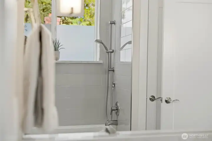 Spa-style bathtub and shower with subway tile, brushed nickel fixtures, and natural light. Spa-style bathtub and shower with subway tile, brushed nickel fixtures, and natural light.