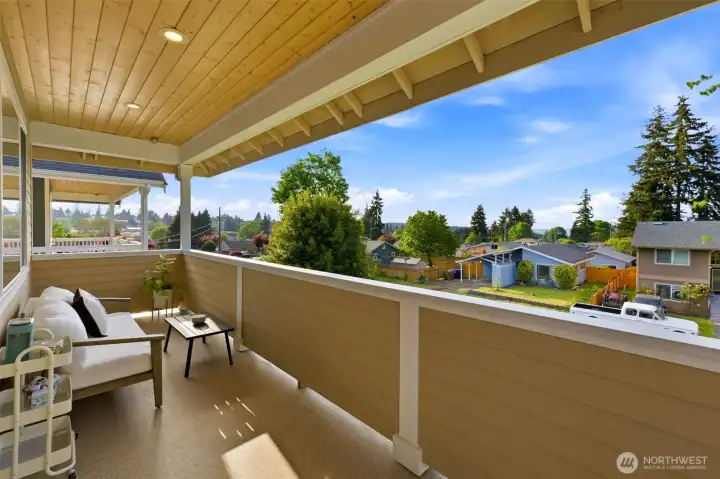 Covered upper deck off the primary — partial Sound and sunset views over the neighborhood rooftops. Covered upper deck off the primary — partial Sound and sunset views over the neighborhood rooftops.