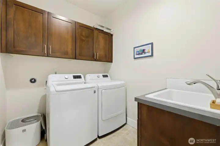 Dedicated upstairs laundry room with LG washer and dryer, utility sink, and built-in cabinetry — near all four bedrooms. Dedicated upstairs laundry room with LG washer and dryer, utility sink, and built-in cabinetry — near all four bedrooms.