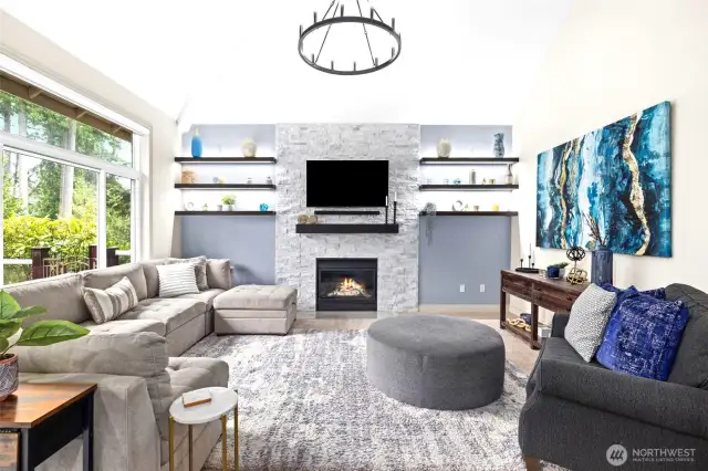 Updated Living room, tall ceilings, stone fireplace, wooden shelves, & designer paint and fixtures.