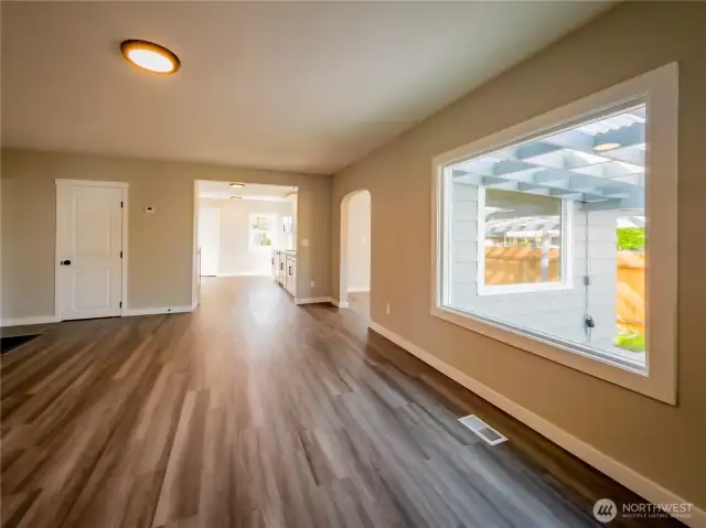 FROM THE HUGE LIVING ROOM INTO THE DINING/DEN/OFFICE AREA AND KITCHEN