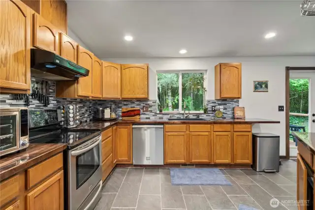 Custom butcher block countertops, SS appliances, tile backsplash