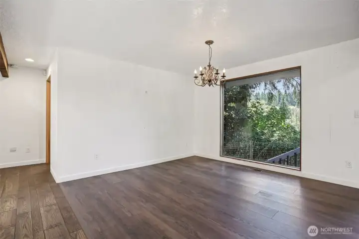 This large picture view window of the land, is the dinning room area, with sweeping views of the landscape and large deck area. Notice the stairs to the garage and shop area.