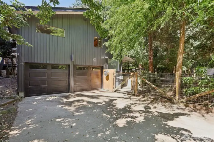 Around the south side of the home,  take the stairs from the front of the home....see the gate.  See the two covered garages and they are deep with a shop area in the front.
