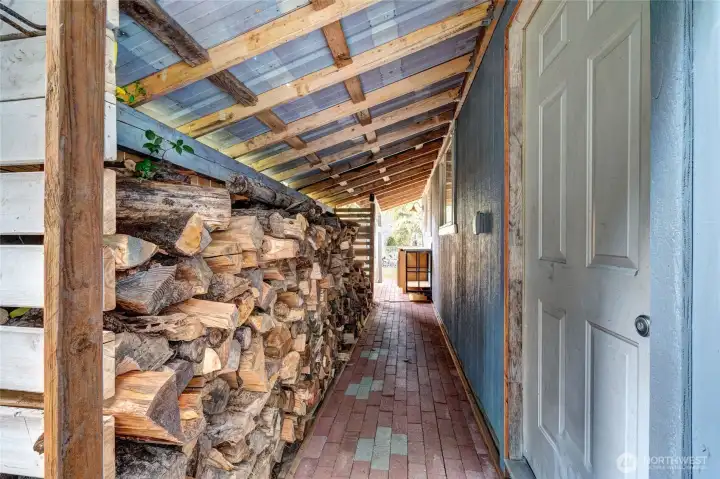 Covered wood storage behind detached 2 car garage