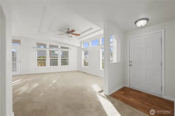 Sunlight fills every corner, highlighting the detailed ceiling and ceiling fan, creating a warm and welcoming atmosphere from the moment you step inside.