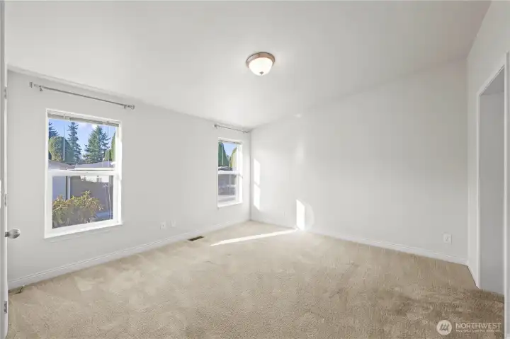 Step into the spacious primary bedroom filled with natural light, offering a peaceful retreat with room to relax and unwind.