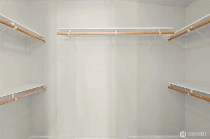 A spacious master closet with built-in shelving provides plenty of room to organize clothing, shoes, and accessories with ease.