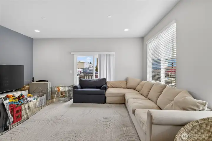 Spacious living room featuring plush seating, plentiful natural light, and cozy ambiance