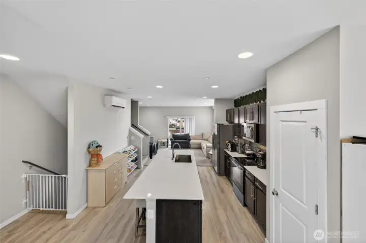 Sleek modern kitchen with white cabinetry and open flow to dining and living spaces