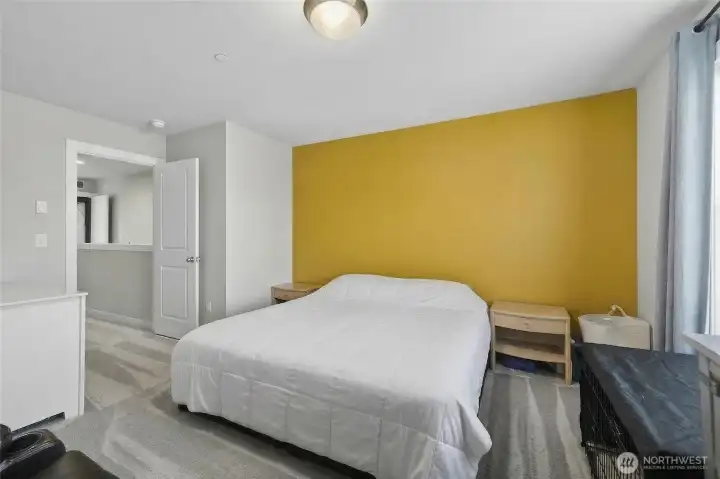 Master suite bedroom with bold accent wall, generous closet space, and refined contemporary style