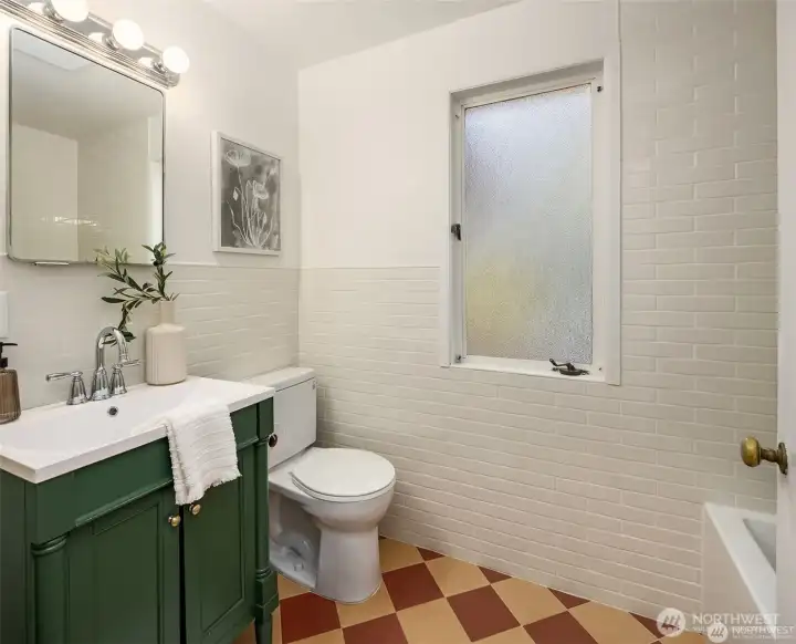Secondary main level bathroom with bathtub.