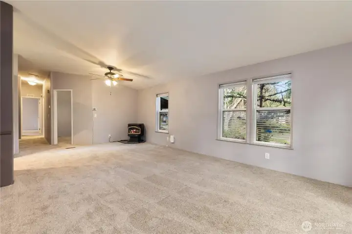 great room with vaulted ceiling & pellet stove