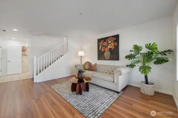 The entry level welcomes you with a bright flex-living space featuring fresh paint, warm natural light, and an inviting open layout. Just off this area, you’ll find a convenient downstairs powder room and a well-appointed laundry room that provides direct access to the garage. A set of stairs leads you seamlessly up to the main level, creating an easy and functional flow throughout the home.