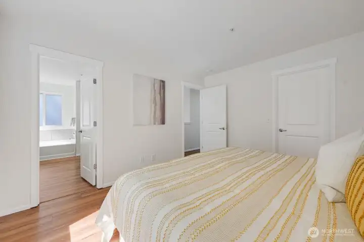 Spacious primary suite offers a serene retreat with a bright, airy layout and a seamless connection to its private ensuite. The adjoining primary bathroom features a relaxing soaking tub, a generous walk-in closet, and a clean, modern design that enhances everyday comfort. It’s a thoughtfully designed space that blends function and tranquility for a true retreat-style experience.