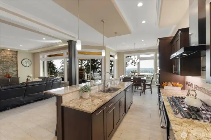 Gourmet kitchen features granite bar, eating area, gas range, double oven and walk in pantry