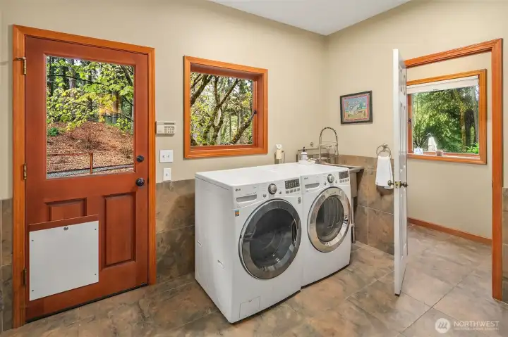 Off the kitchen - a mudroom/laundry room has a dog door to a safely fenced enclosure.
