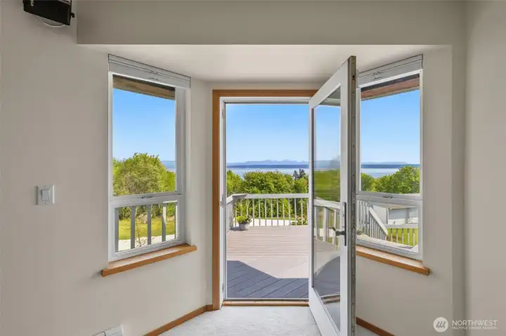 Primary suite's french door to the deck. Take your cup of morning coffee out there to watch the sunrise over Port Susan Bay and the Cascade Range!