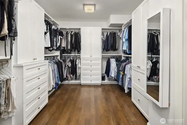 Lavish primary walk-in closet boasting high-end custom built-in systems. Features extensive wardrobe hanging space and an impressive, dedicated additional storage design optimized for a premium shoe collection. Lavish primary walk-in closet boasting high-end custom built-in systems. Features extensive wardrobe hanging space and an impressive, dedicated additional storage design optimized for a premium shoe collection.