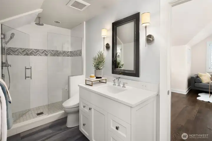 A beautifully appointed 3/4 bathroom that balances luxury and functionality. The space features a dedicated, built-in seated makeup vanity with custom lighting, a modern glass-enclosed step-in shower, and direct access to a generous walk-in closet with built-in organization. A beautifully appointed 3/4 bathroom that balances luxury and functionality. The space features a dedicated, built-in seated makeup vanity with custom lighting, a modern glass-enclosed step-in shower, and direct access to a generous walk-in closet with built-in organization.