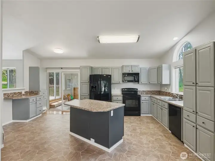 Island kitchen with plenty of cabinets, island, counter space. Sliding door to the left is out to the sun room. Island kitchen with plenty of cabinets, island, counter space. Sliding door to the left is out to the sun room.