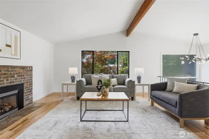 The main level features refinished hardwood floors, vaulted ceilings, and generous windows framing the beautiful Japanese maple in the front yard.